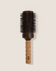 Hairbrush with cork handle and brown bristle head on a beige background