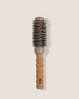 Hairbrush with cork handle and 'REN' branding on a beige background