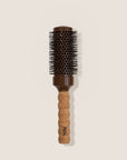 Hairbrush with cork handle and brown bristle head on a beige background